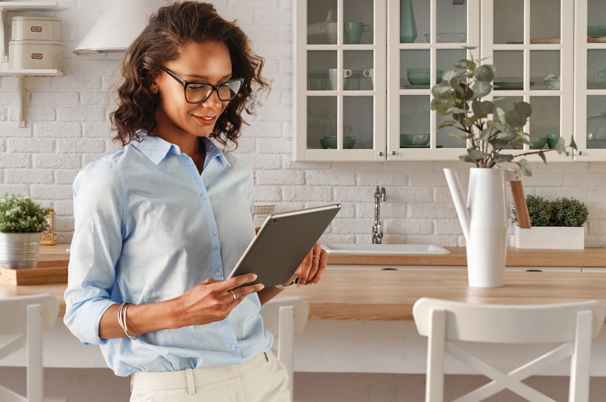 woman in kitchen smiling on ipad signup